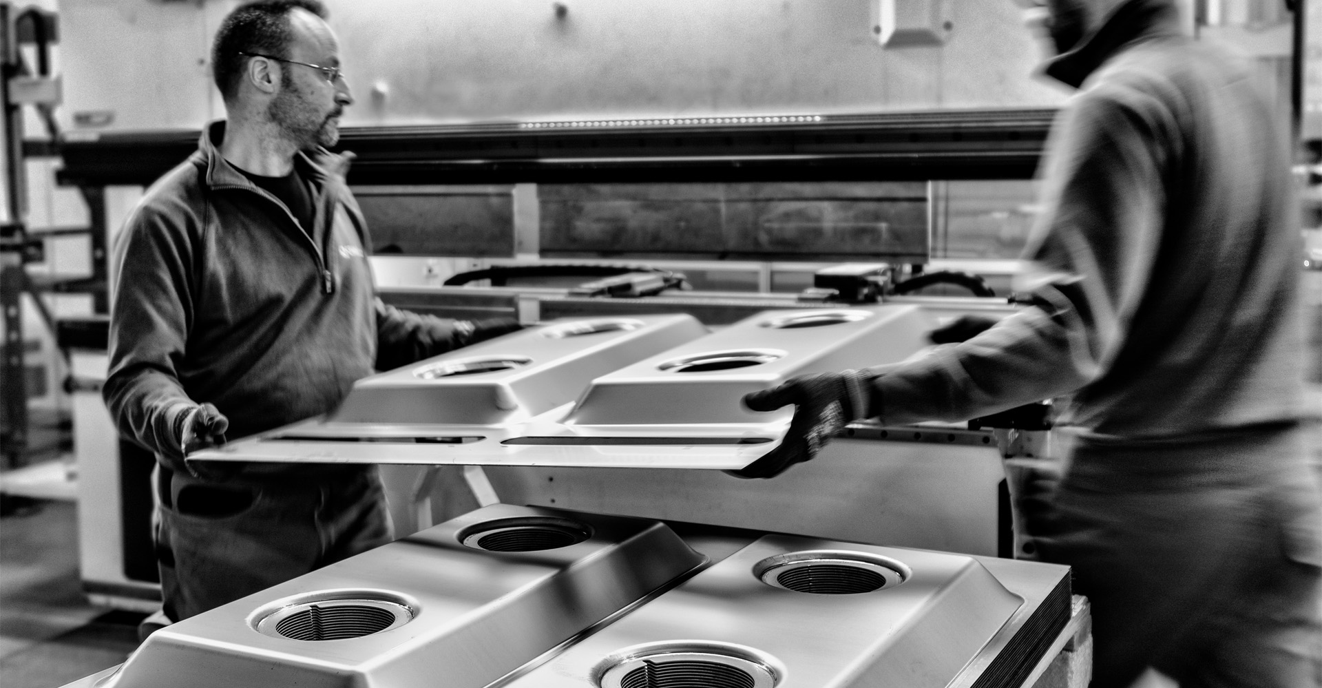 due uomini trasportano un piano cottura ancora in fase di montaggio