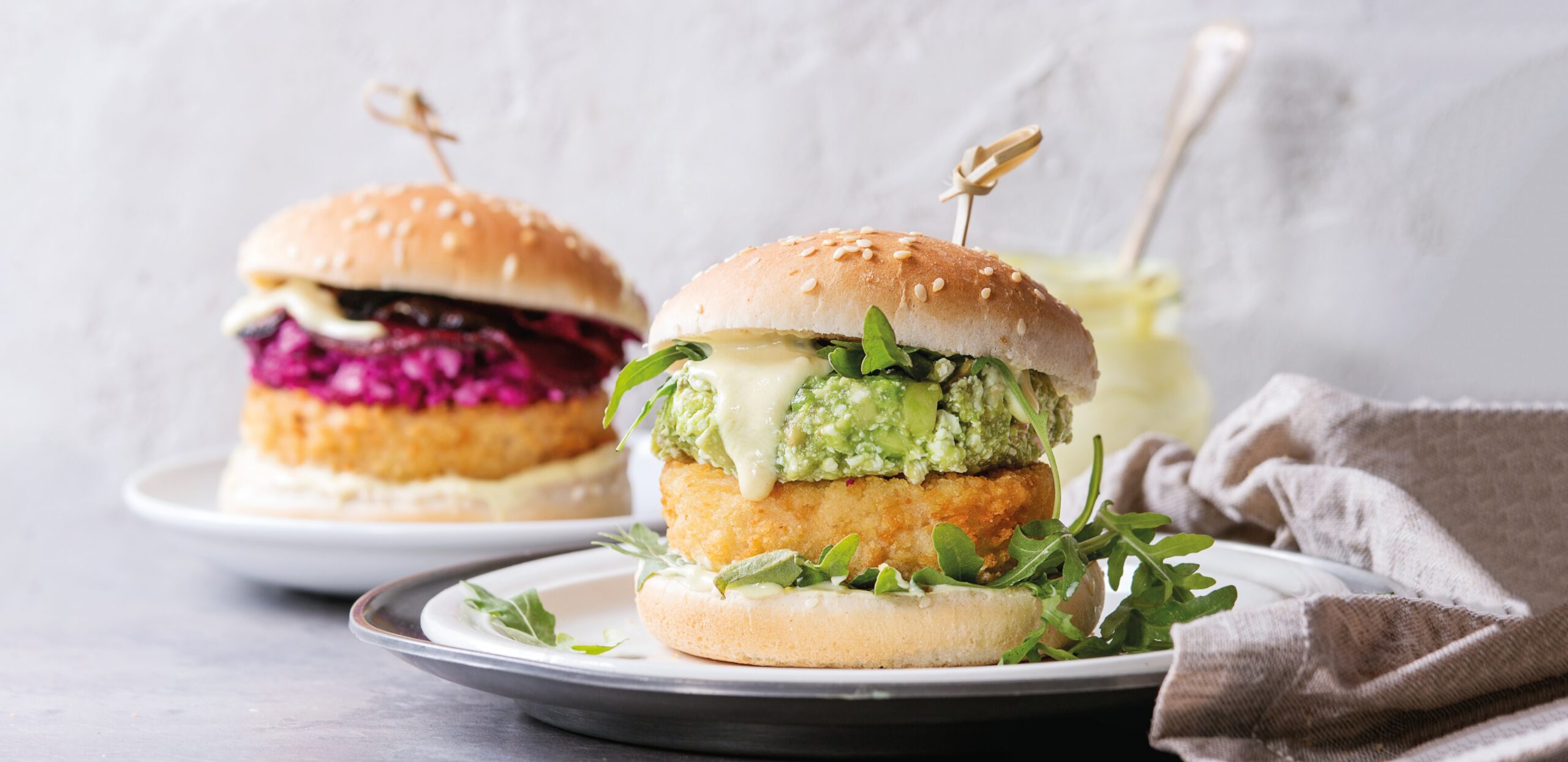 Due piatti con panini, ripieni con burger vegetali e pollo fritto