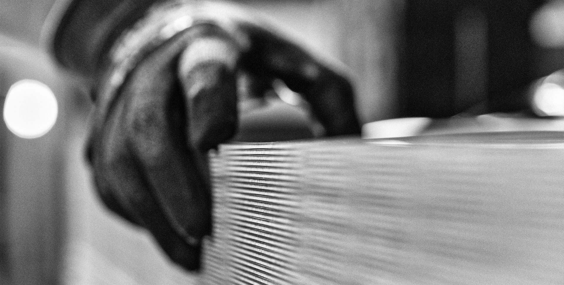 dettaglio di una mano con un guanto che tocca un pezzo di legno