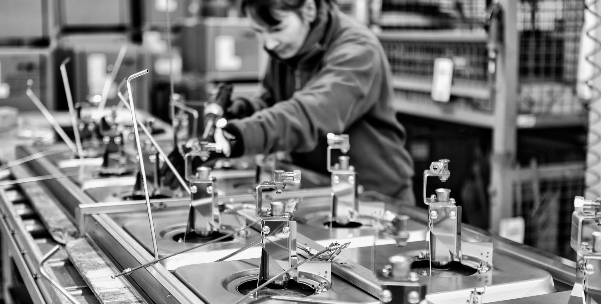 foto in bianco e nero di donna che lavora su una macchina in acciaio