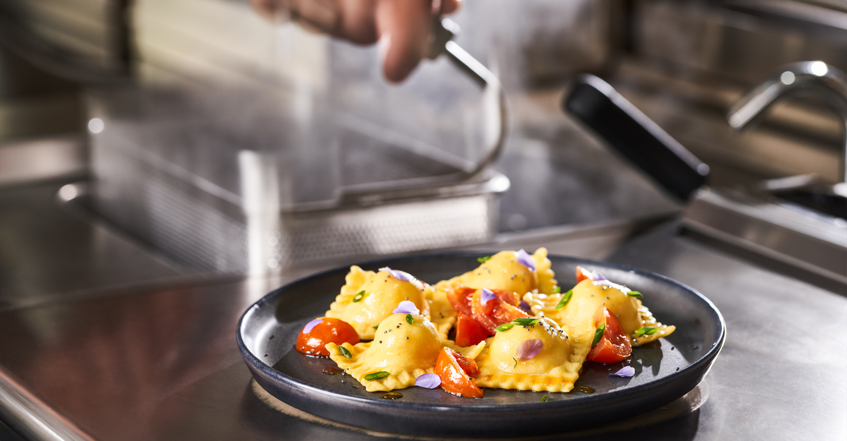 Chef che decora un piatto di ravioli